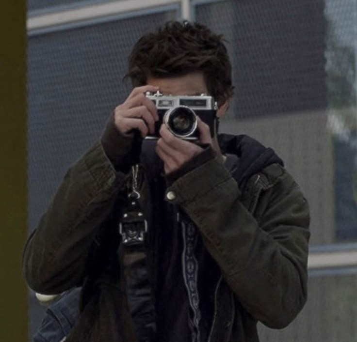 Grayscale editorial photograph of a person holding a camera